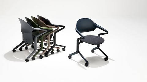 Four Fuld Nesting Chairs in various colors and finishes nested in a group next to a single Fuld Nesting Chair in Nightfall with the 3D Knit textile.