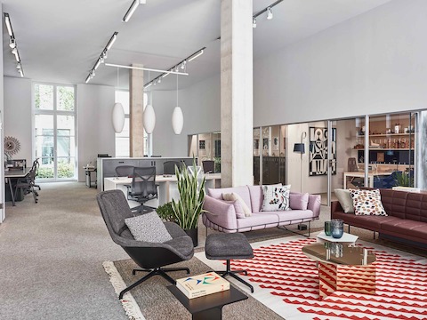 Lounge setting in the Paris showroom, featuring Wireframe and Tuxedo sofas and a grey Striad chair and ottoman.
