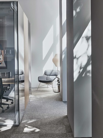 View of a walkway through the Paris showroom, with a Striad chair at one end.
