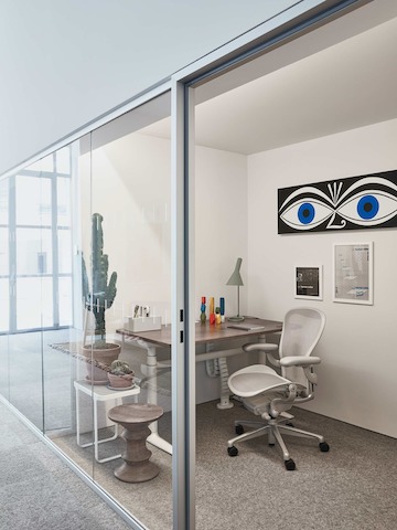 A private, glass walled office within the Paris showroom, with an Aeron chair and Atlas desk.