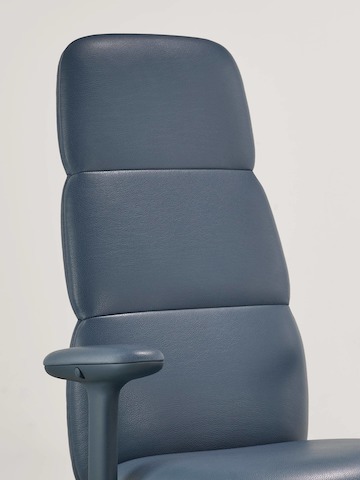 Detail view of a high-back Asari chair by Herman Miller in dark blue leather with height adjustable arms