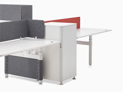 A collaboration cluster of three height-adjustable Atlas Office Landscape desks with grey privacy screens.