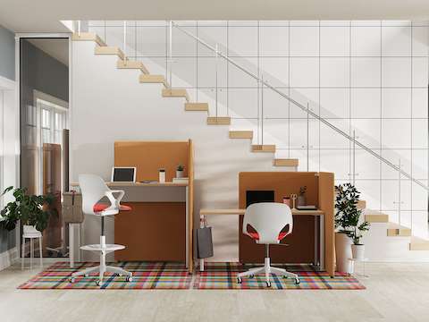 A bright office setting with light brown Bound Freestanding Screens around OE1 tables with white and red Zeph chairs.