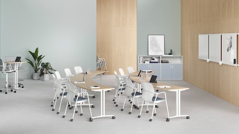Two rows of curved Everywhere Tables in a learning environment, combined with Caper chairs and two standing height tables at the rear of the room.