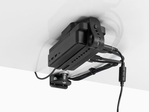 Loop Micro Mount attached under a desk cradling a thin client or power docking station with attached cables that are routed tidily to the edge and above the desk.