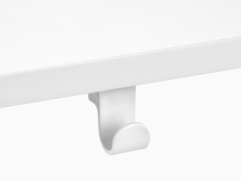 A Ubi Bag Hook affixed to the underside of a work surface.