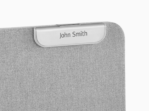 A Ubi Name Tag attached to a fabric-covered panel.