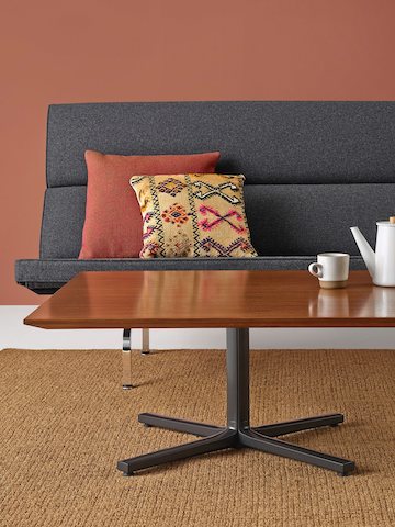 A walnut Everywhere Table arranged in front of an Eames Sofa Compact.