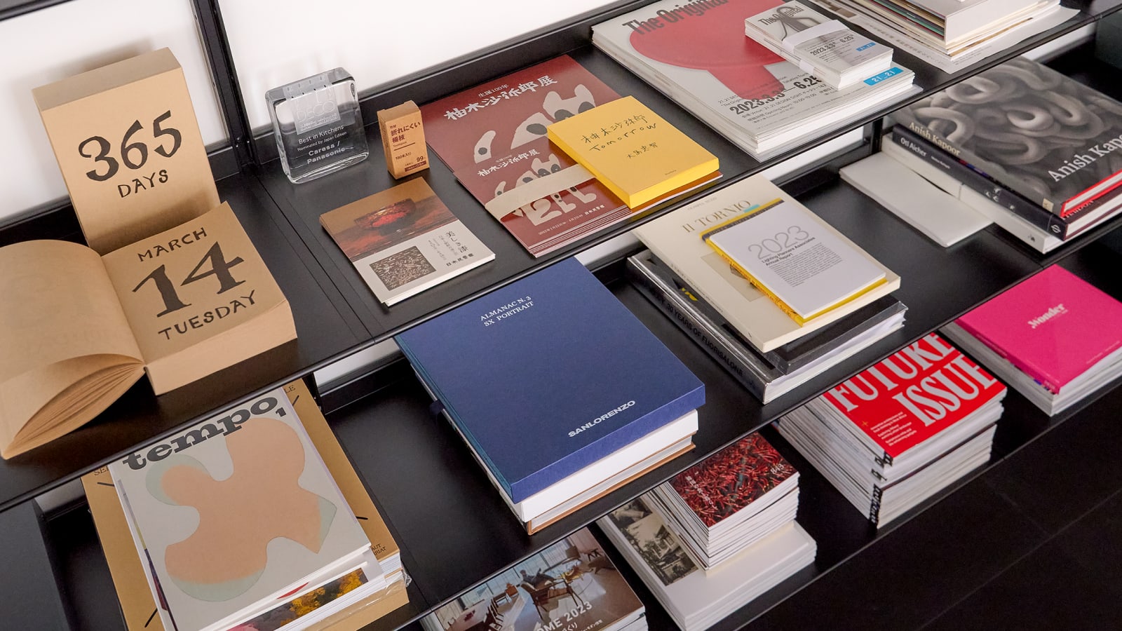 Several books like multiple black shelves in Naoto Fukasawa's studio