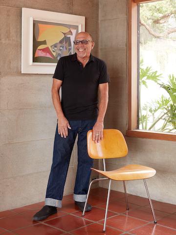 Steve Cabella standing behind an Eames Moulded Plywood Dining Chair.