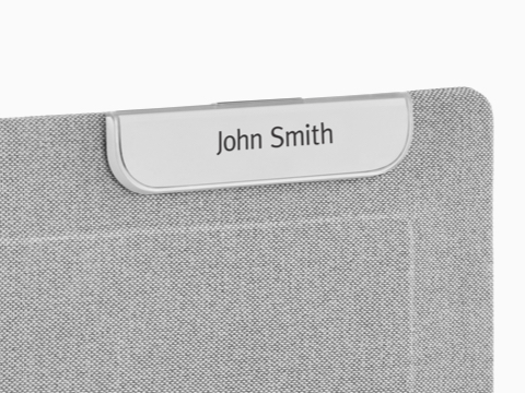 A Ubi Name Tag attached to a fabric-covered panel.