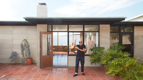 Steve Cabella in front of his San Francisco Bay home with Eames shell chairs in the background.