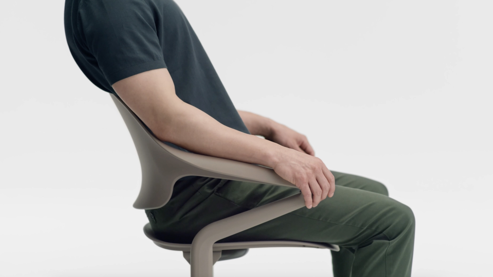 A man leans back in a Cocoa Fuld Nesting Chair. 