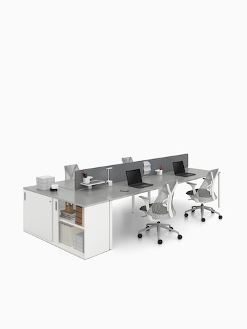 A Paragraph Storage unit containing books and binders extends a benching layout featuring Sayl Chairs. Select to go to the Paragraph Storage product page.