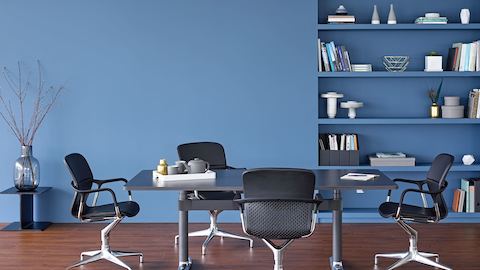 Four Keyn side chairs surround a rectangular Atlas Office Landscape table with a black top.